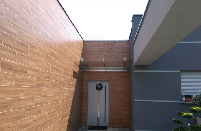 szklany daszek typu SAT nad wejściem do nowoczesnego domu jednorodzinnego